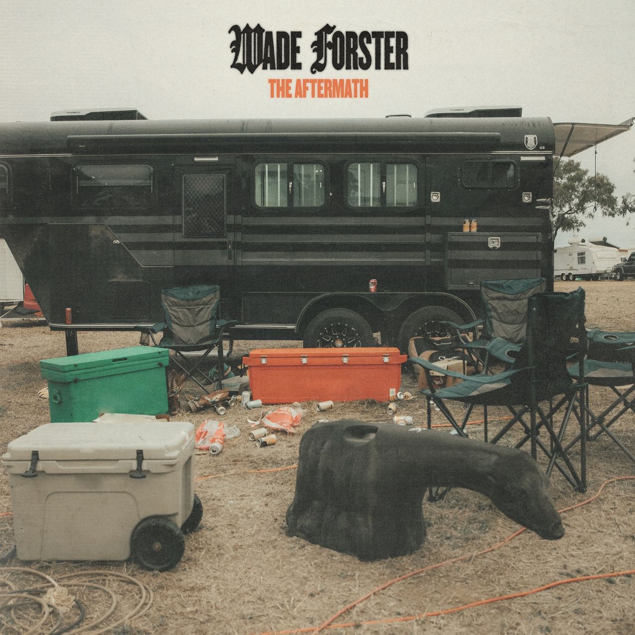 Album cover for Wade Forster's The Aftermath featuring a messy campsite with coolers, lawn chairs, and beer cans in front of a black horse trailer.